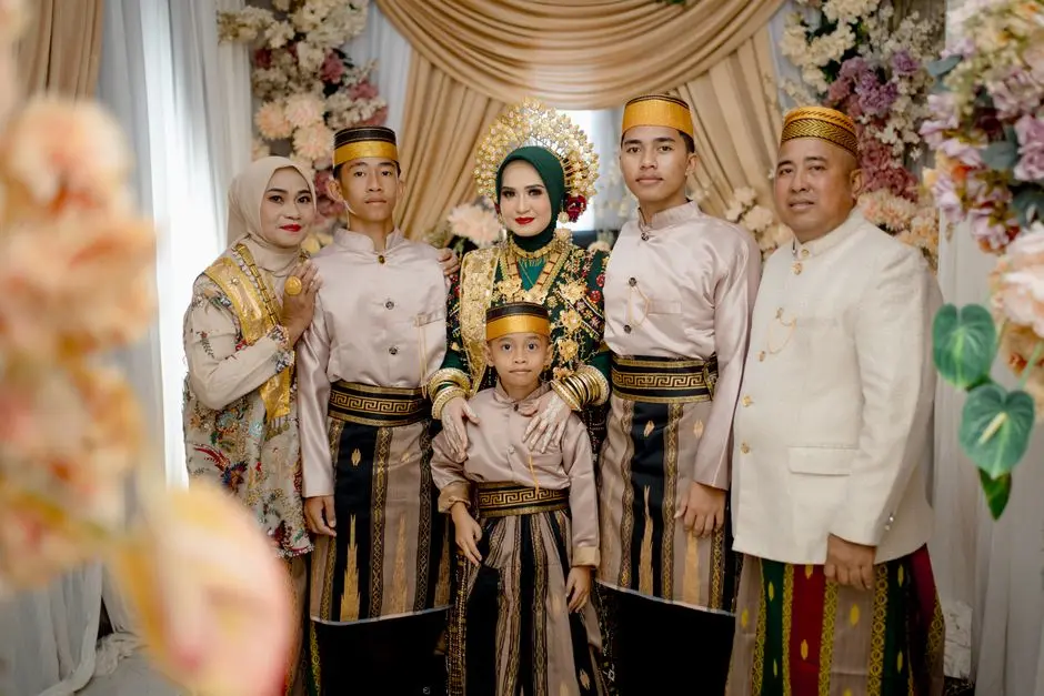 Wanita Indonesia tersenyum memakai baju rapi dengan latar dekorasi acara